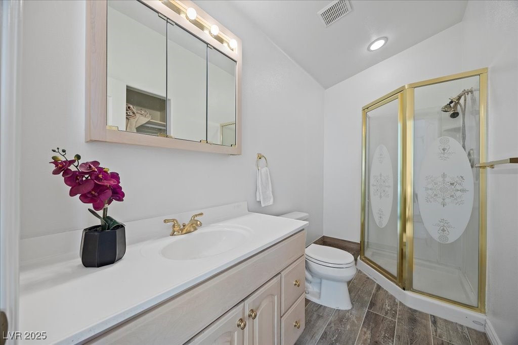 640 Quail Covey Road Henderson, NV 89002 - Photo 42 of 75 Full bathroom featuring vanity, a shower stall, wood finished floors, and vaulted ceiling