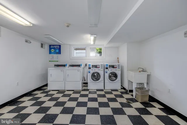 a kitchen with a checkered floor and white cabinets