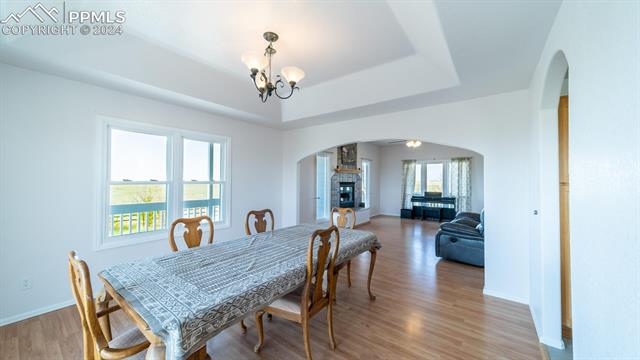 11125 Eureka Road Calhan, CO 80808 - Photo 14 of 44 Dining area with a healthy amount of sunlight, hardwood / wood-style floors, and a raised ceiling