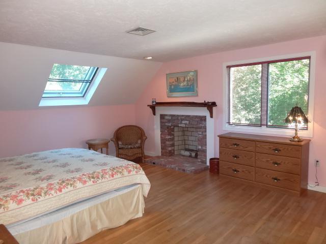258 Huckins Neck Road Centerville, MA 02601 - Photo 22 of 30 a bed room with a bed and a fireplace