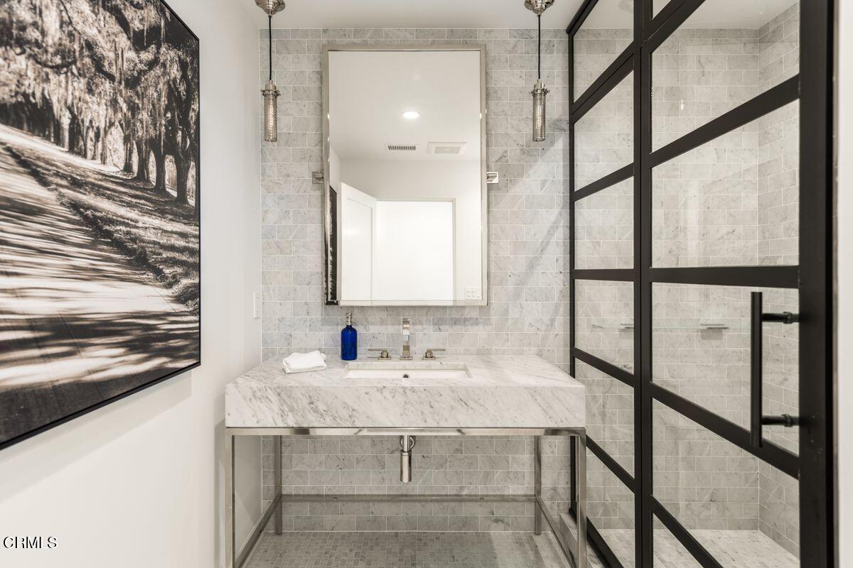 291 Saddle Lane Ojai, CA 93023 - Photo 31 of 47 a bathroom with a granite countertop sink and a large mirror