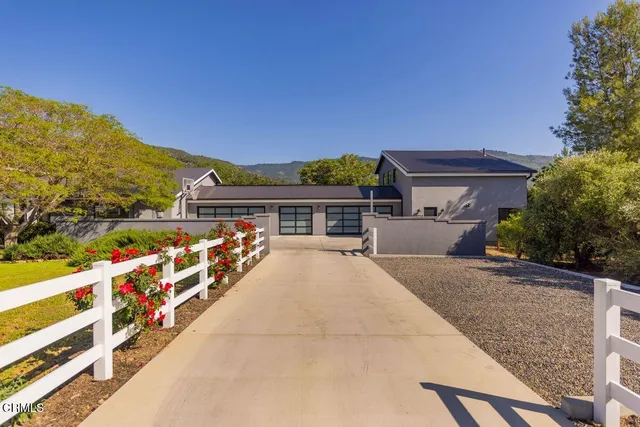 a front view of house with yard and mountain view in back