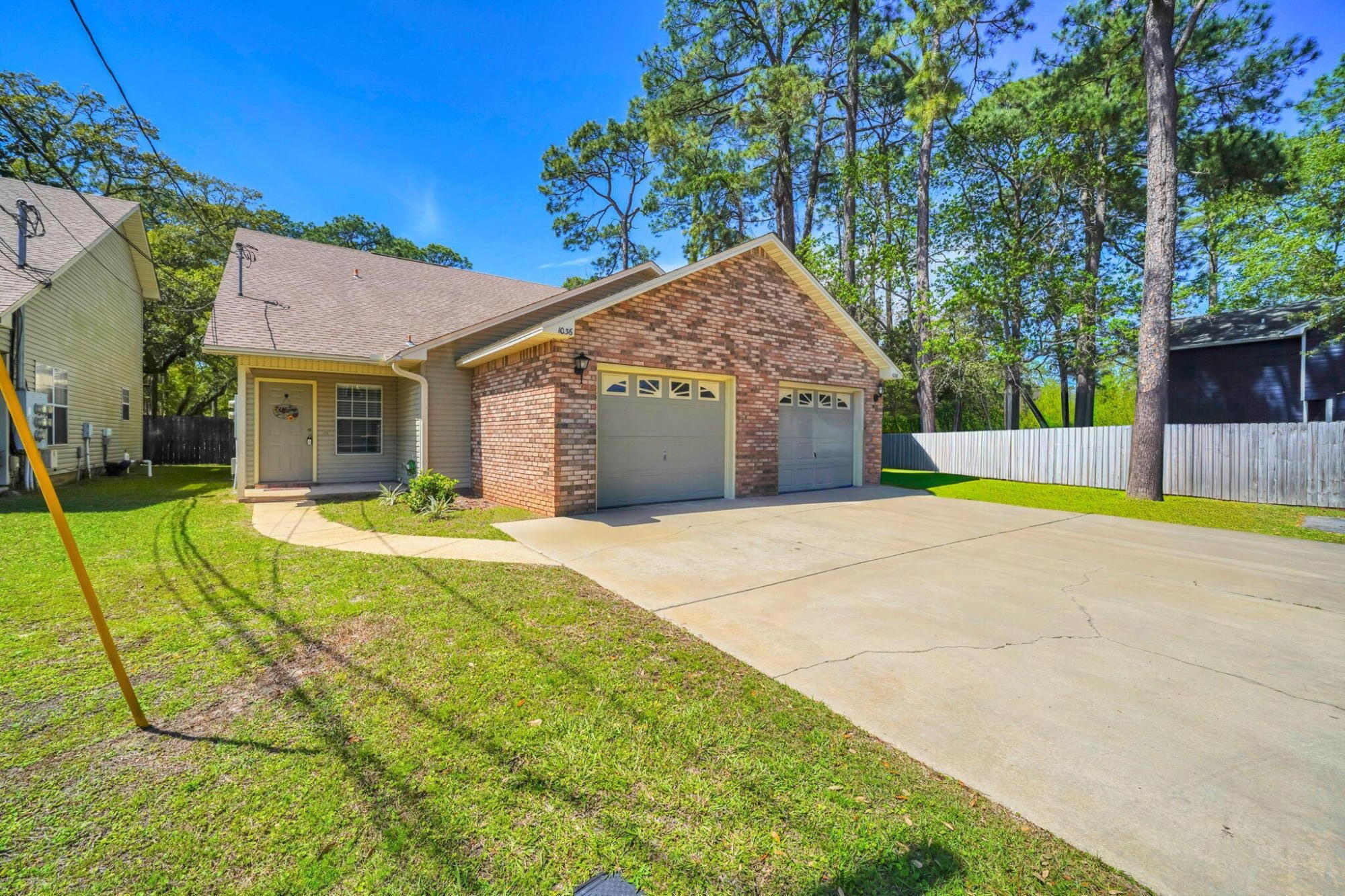 a view of yellow house with swimming pool and next to a yard