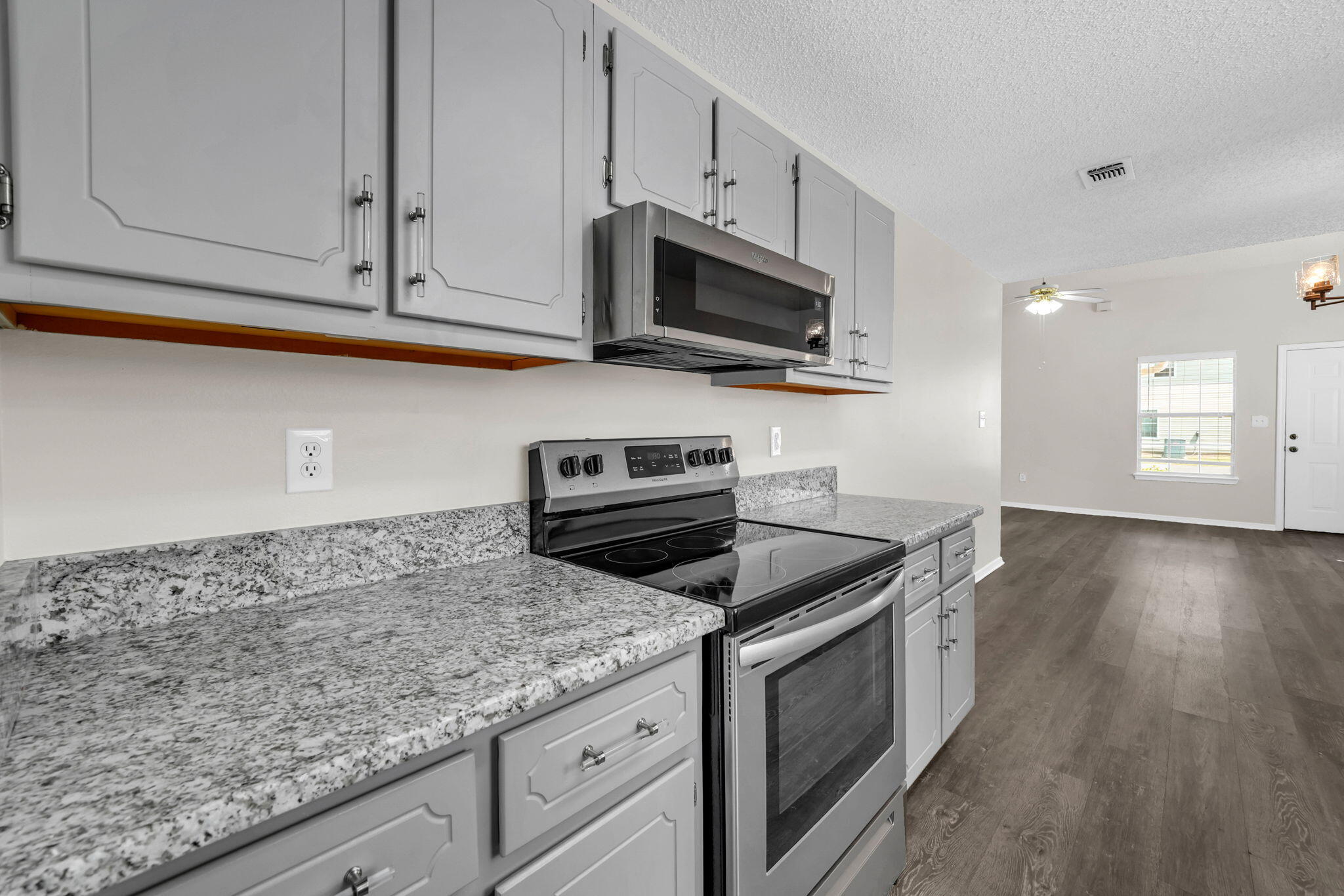 1036 Blue Ridge Drive Fort Walton Beach, FL 32547 - Photo 13 of 31 a kitchen with granite countertop a sink dishwasher stove and microwave with wooden floor