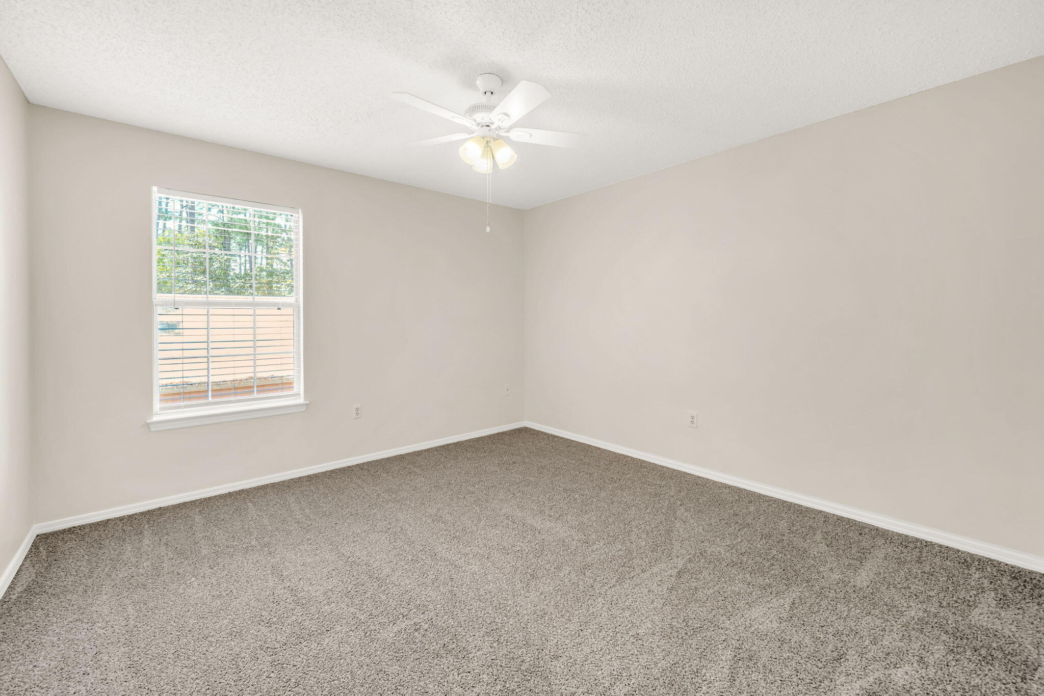 1036 Blue Ridge Drive Fort Walton Beach, FL 32547 - Photo 23 of 31 an empty room with a chandelier fan and windows