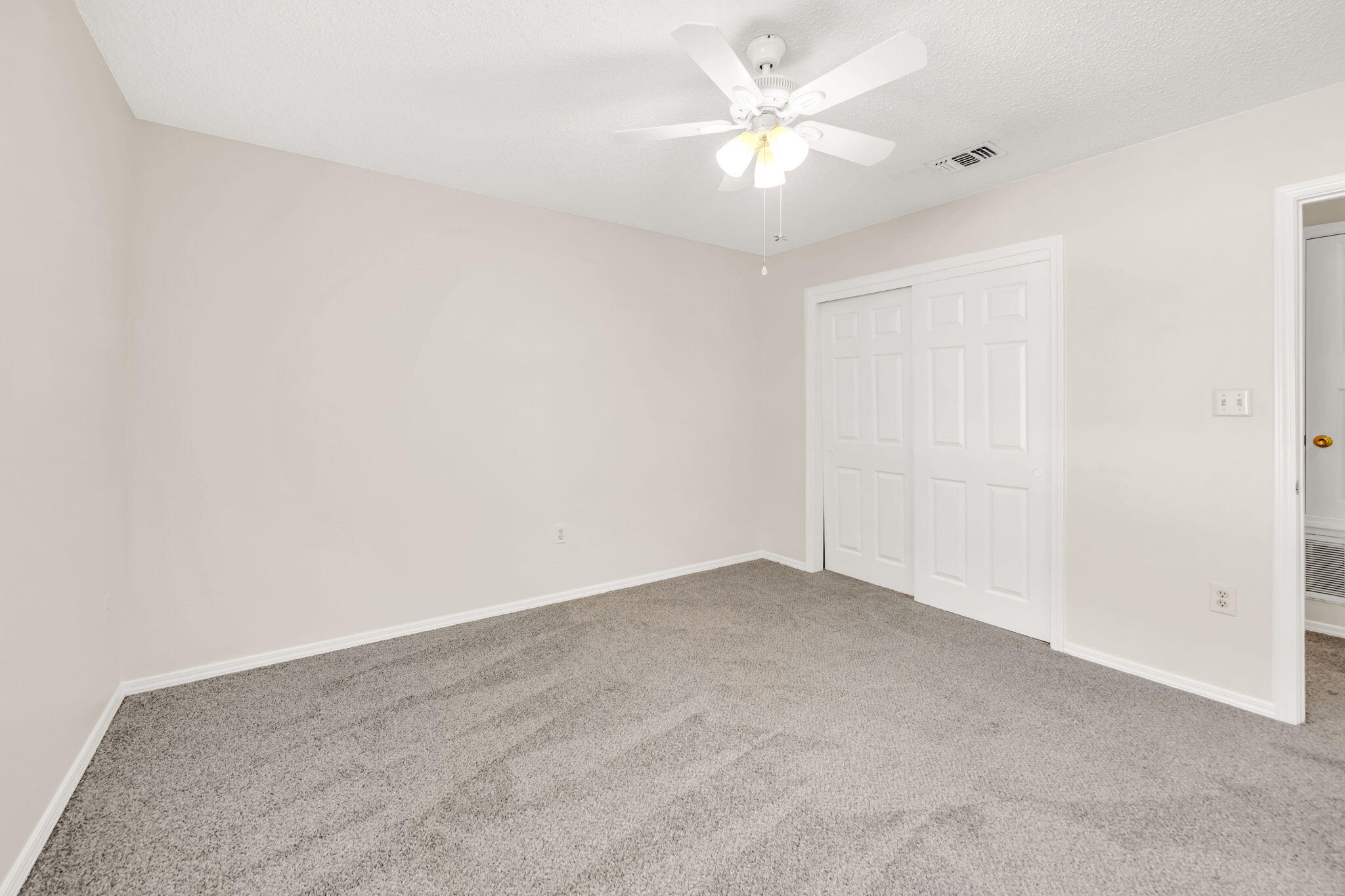 1036 Blue Ridge Drive Fort Walton Beach, FL 32547 - Photo 24 of 31 an empty room with a chandelier fan and windows