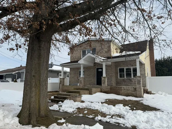 a front view of a house with a yard covered in snow