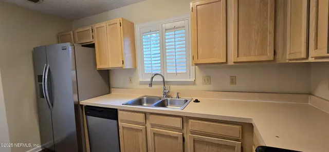 a kitchen with stainless steel appliances a refrigerator sink and cabinets