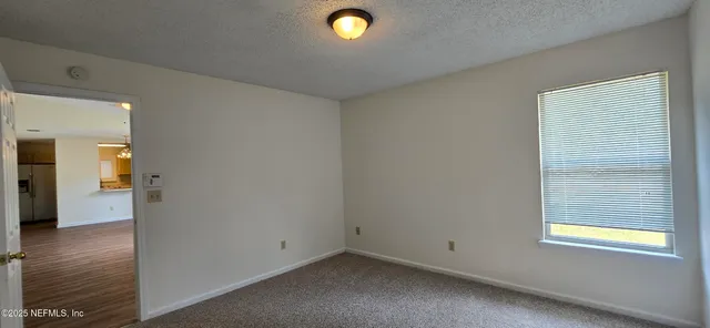 an empty room with closet and windows