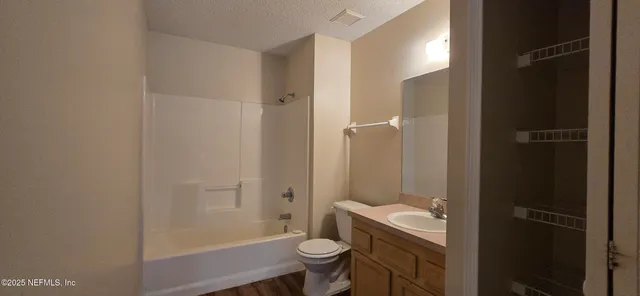 a bathroom with a granite countertop toilet a sink and shower