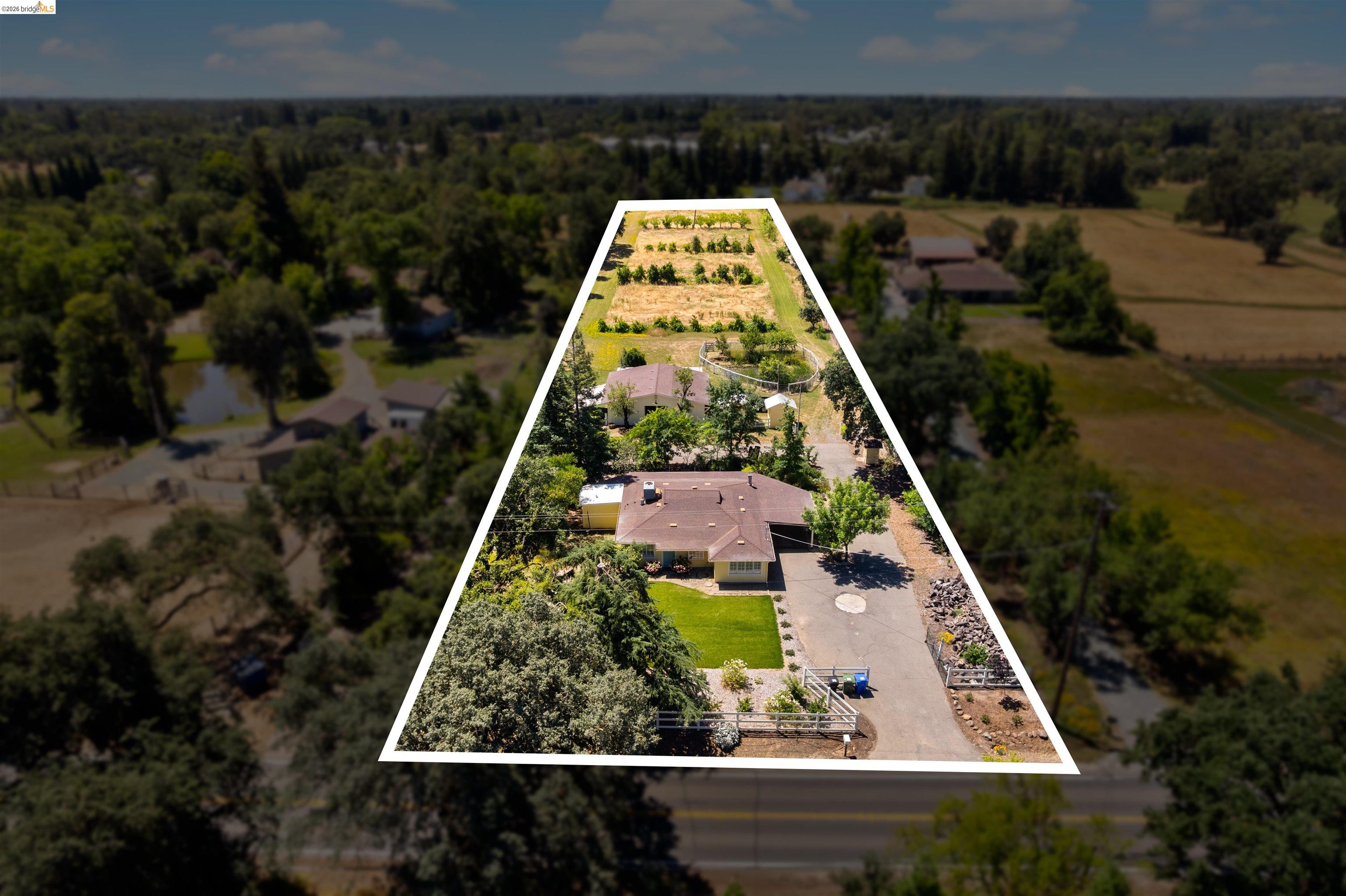 10474 Sheldon Road Elk Grove, CA 95624 - Photo 68 of 83 Expansive property featuring a single-story residence with a brown shingle roof, a gravel driveway, and a manicured lawn