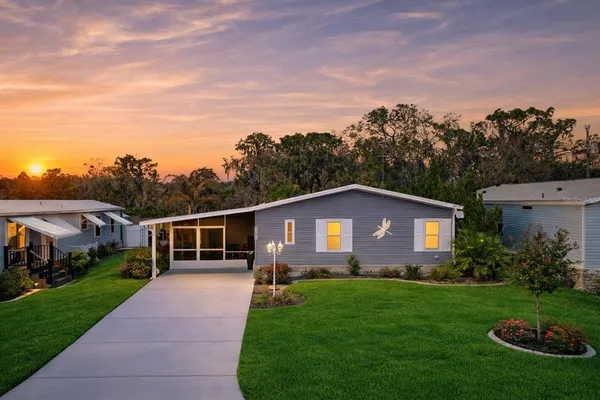 a front view of a house with a garden and yard