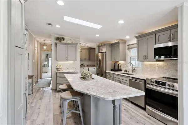 a kitchen with stainless steel appliances granite countertop a stove refrigerator and a microwave