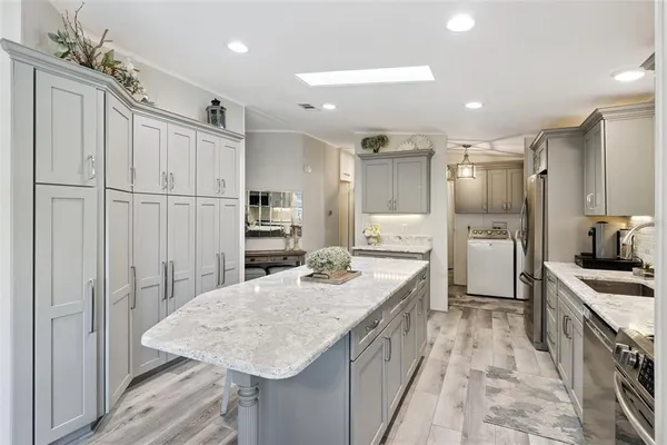 a kitchen with stainless steel appliances granite countertop a sink refrigerator and cabinets