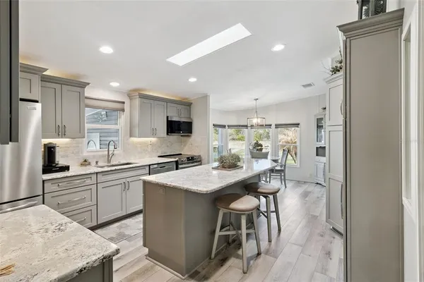 a kitchen with stainless steel appliances kitchen island granite countertop a sink and cabinets