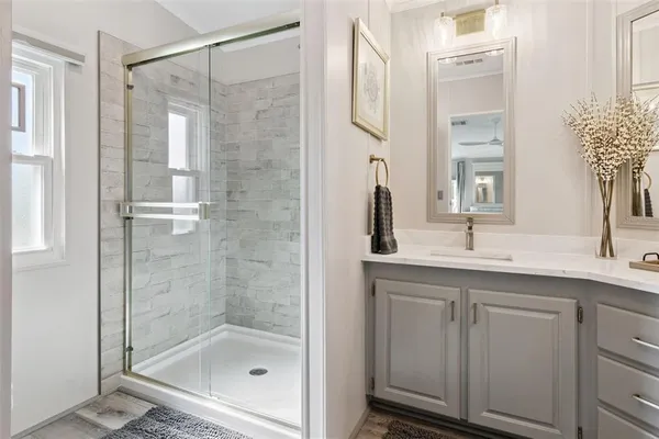 a bathroom with a shower sink and mirror