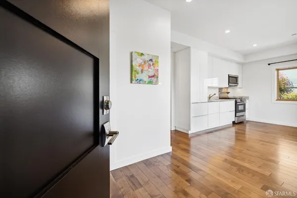 a view of a kitchen with wooden floor and electronic appliances