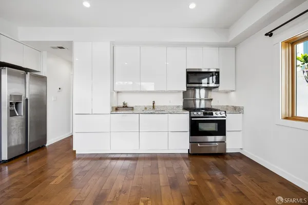 a kitchen with wooden floors and appliances