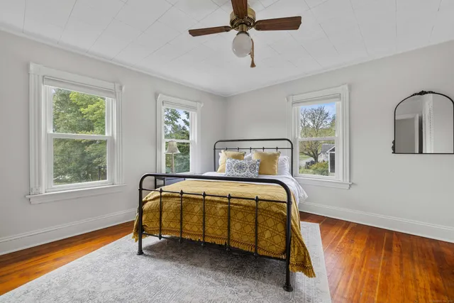 a spacious bedroom with a bed and a flat screen tv