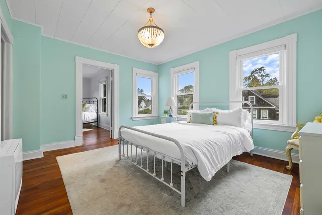 a hallway with wooden floor and cabinet