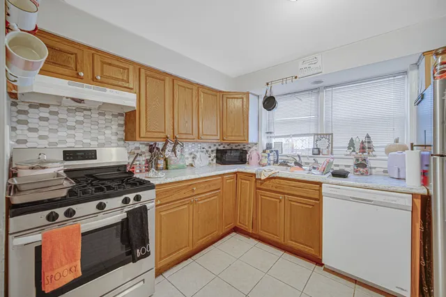 a kitchen with stainless steel appliances a stove sink and cabinets