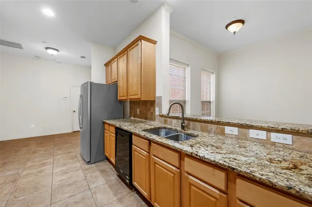 a kitchen with stainless steel appliances granite countertop a sink refrigerator and cabinets