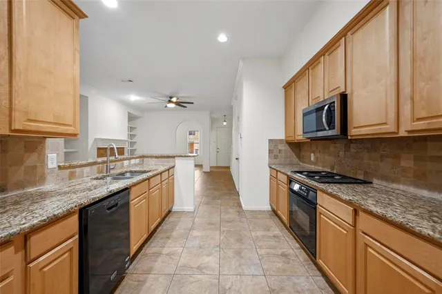 a large kitchen with stainless steel appliances granite countertop a stove sink and cabinets