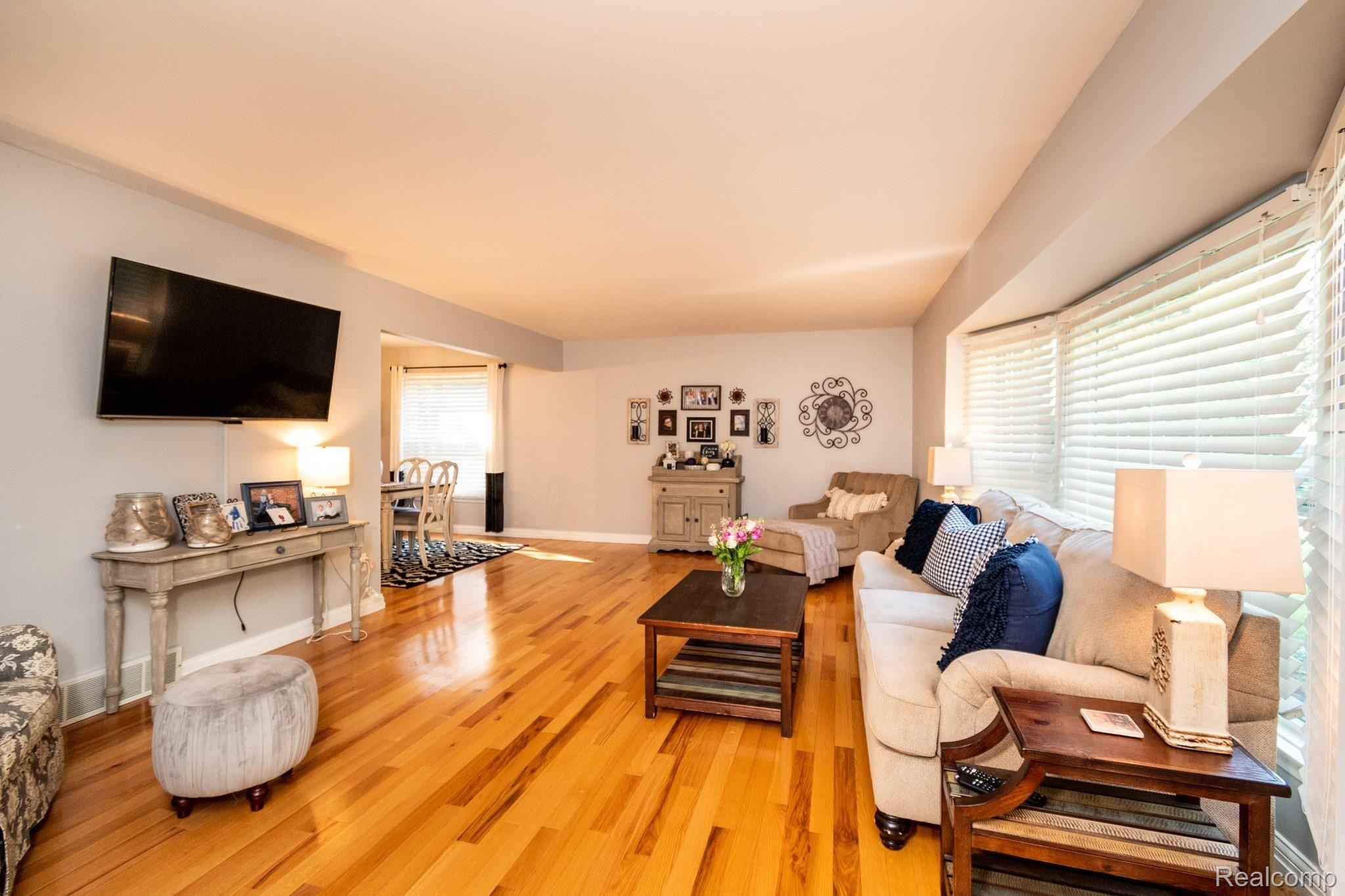 616 Campus Road Rochester, MI 48309 - Photo 9 of 38 Beautiful hardwood flooring is brightly lit by large windows.
