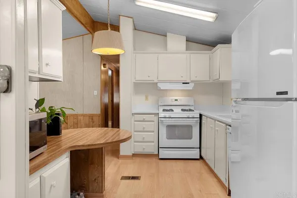 a kitchen with stainless steel appliances granite countertop a sink a stove and refrigerator