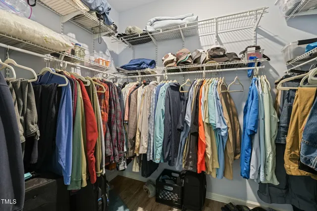 a view of walk in closet with clothes and shoes