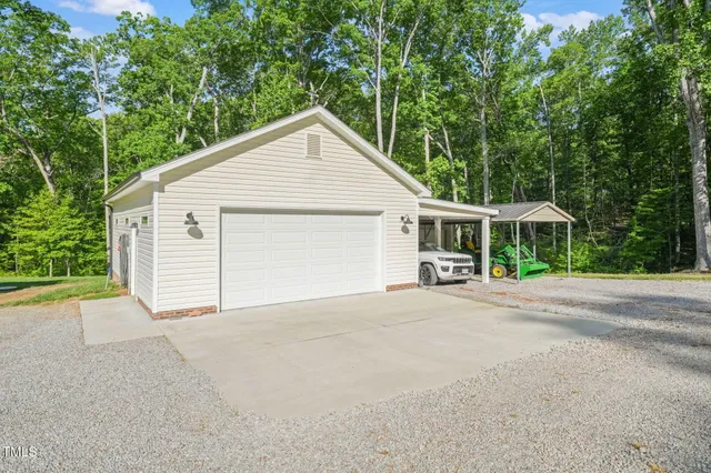 a view of a house with a yard and large trees