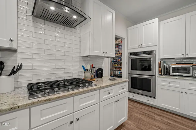 a kitchen with white cabinets and appliances