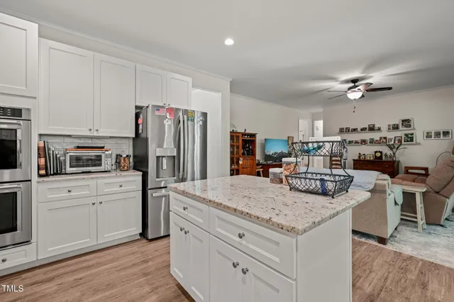 a kitchen with a refrigerator a stove cabinets and wooden floor