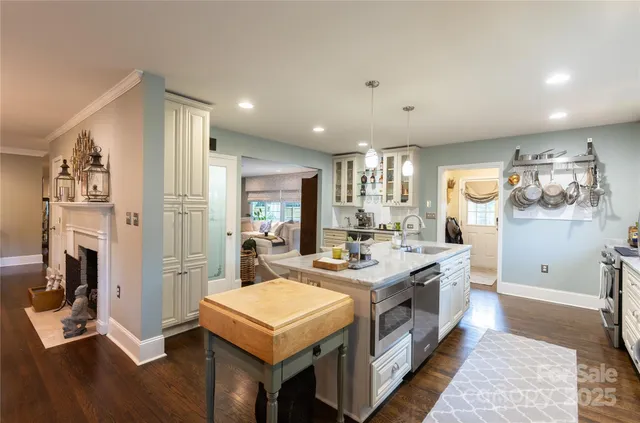 a large kitchen with a counter space a sink appliances and cabinets
