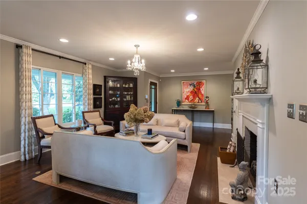 a living room with fireplace furniture and a large window