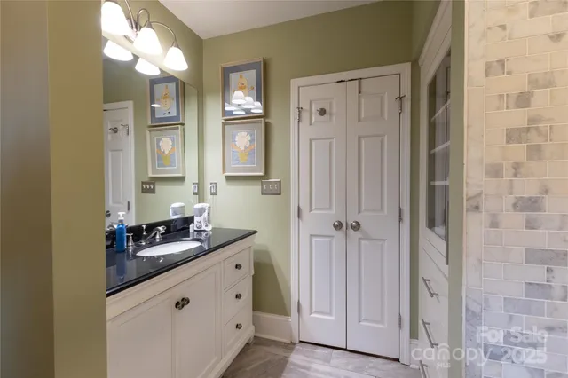 a bathroom with a granite countertop sink a mirror and a shower