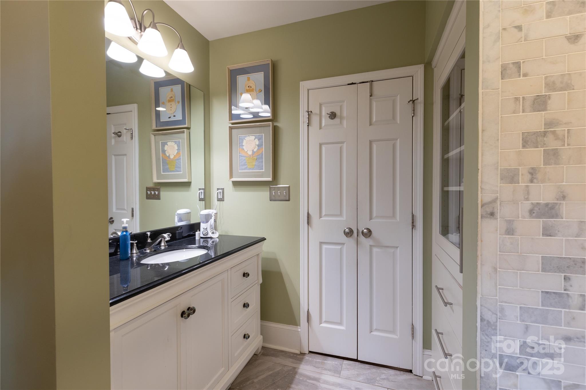 802 East Franklin Street Monroe, NC 28112 - Photo 28 of 48 a bathroom with a granite countertop sink a mirror and a shower