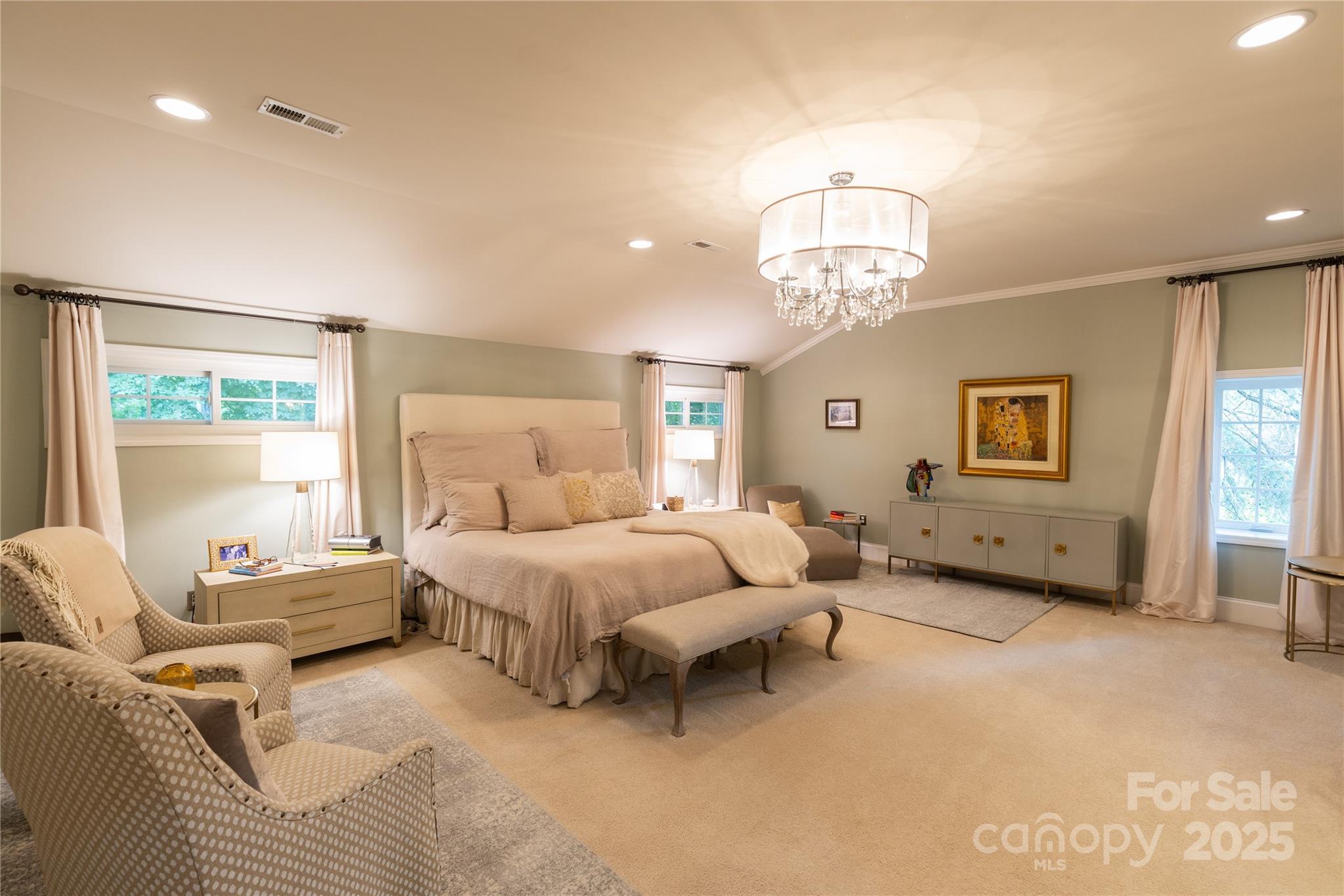 802 East Franklin Street Monroe, NC 28112 - Photo 39 of 48 a spacious bedroom with a bed a chandelier and a window