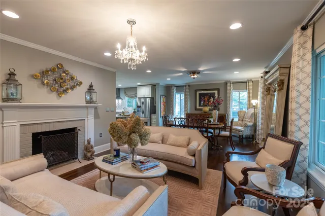 a living room with furniture a fireplace and a chandelier