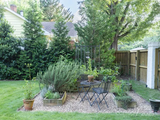 a view of a chair and table in backyard of the house