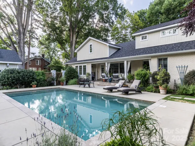 an outdoor sitting area with couch and large trees