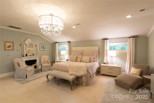 a spacious bedroom with a bed and a chandelier