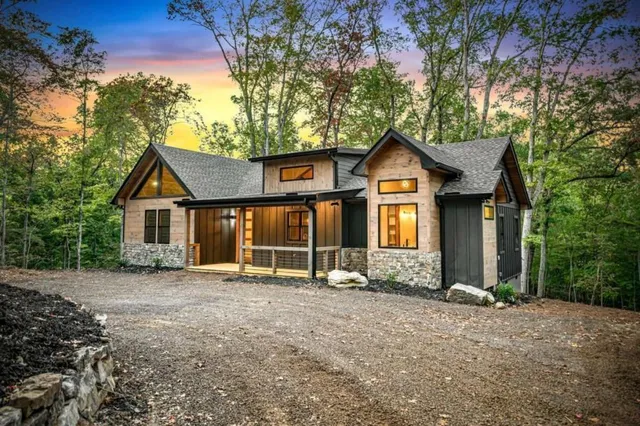 a view of a house with a yard and large tree