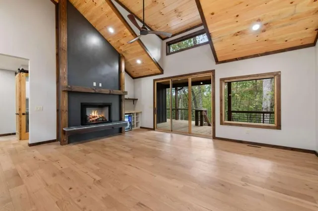 a view of an empty room with a fireplace and a window