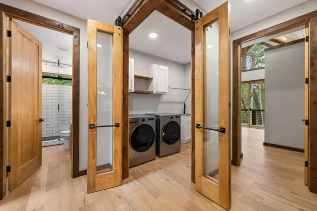 a view of a hallway with wooden floor and a bathroom