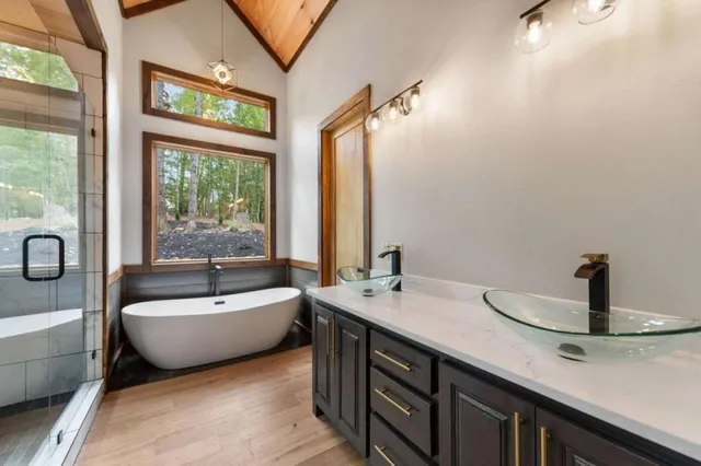 a bathroom with a double vanity sink bathtub and window