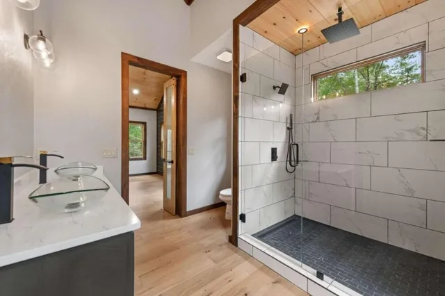 a bathroom with a sink a toilet and shower