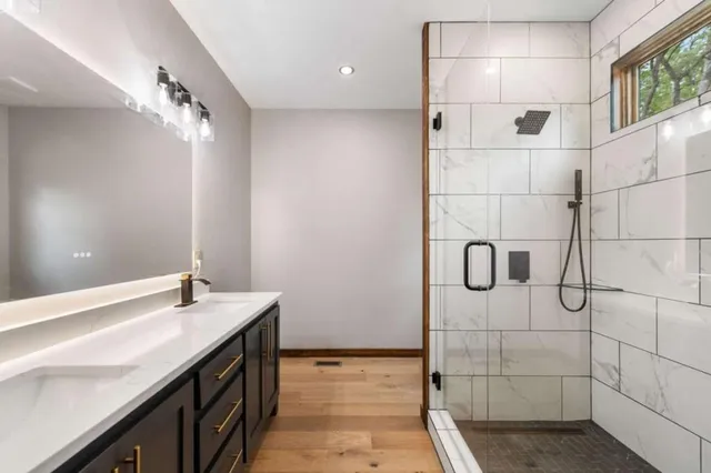 a bathroom with a sink shower and a mirror