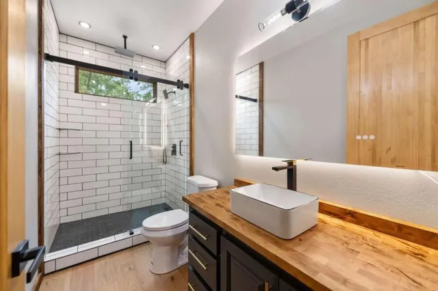 a bathroom with a granite countertop sink toilet and shower