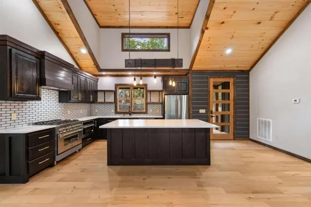a large kitchen with stainless steel appliances granite countertop a stove and a sink